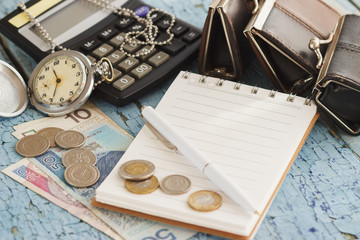 Polish zloty, wallets, pocket clock, notebook and calculator, wooden background