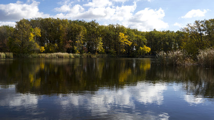 Fototapeta na wymiar A river with autumn trees and beautiful clouds. Travels. Fishing