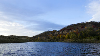 A river with autumn trees and beautiful clouds. Travels. Fishing