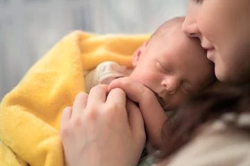 Beautiful woman holding a newborn baby in her arms, © photoprime
