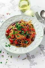 Vegetarian Italian Pasta Alla Puttanesca with garlic, olives, capers with on white plate.