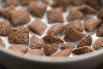 poured with milk chcolate cereal pillow in white bowl