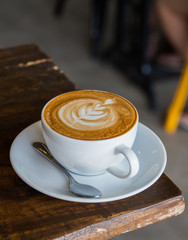 Hot Latte in a cup on the wooden table