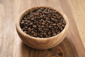 Fototapeta na wymiar roasted coffee beans in wood bowl on table