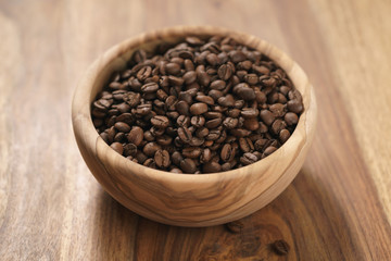 roasted coffee beans in wood bowl on table