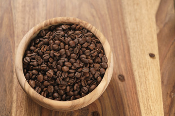 roasted coffee beans in wood bowl on table
