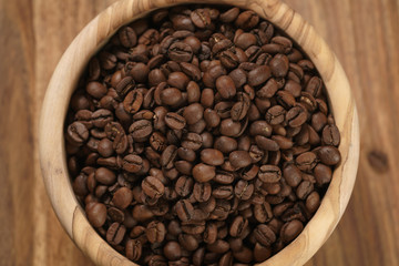 Fototapeta premium roasted coffee beans in wood bowl on table