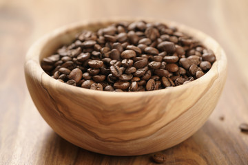 roasted coffee beans in wood bowl on table