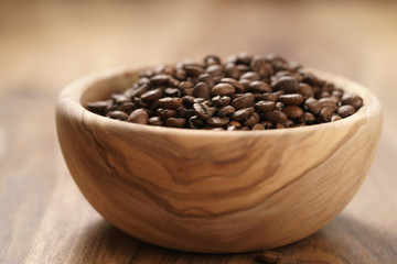 roasted coffee beans in wood bowl on table