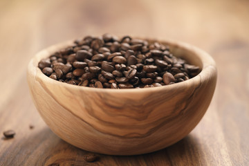 roasted coffee beans in wood bowl on table
