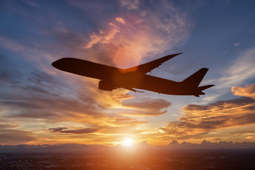 Fototapeta na wymiar The silhouette of a passenger plane flying in sunset.