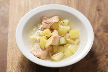 closeup pour fish soup with trout into bowl