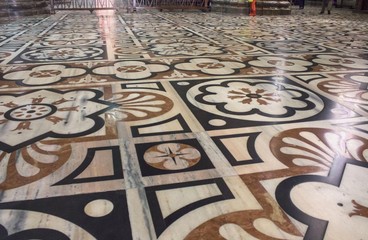 Inside Duomo cathedral in Milan, detail of the decorated floor in candoglia marble with flower pattern