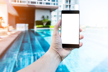 close up of male hand holding smartphone on swiming pool