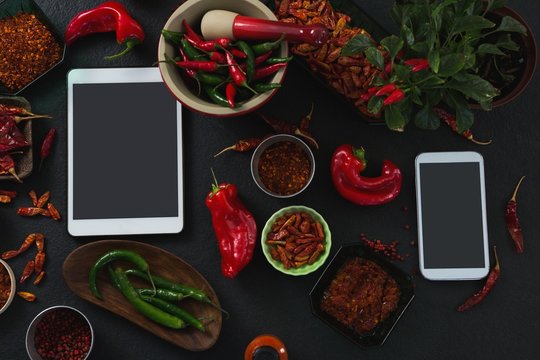 Various spices with digital tablet and mobile phone on black - Powered by Adobe