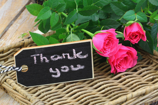 Thank you written on mini blackboard with one pink rose on wicker tray
