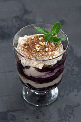 layered dessert with blueberries and cream on black background