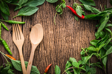 wooden spoon with chili and basil asian herb and in gredients on old vintage wooden texture background