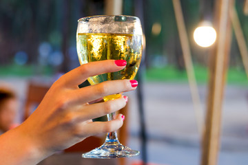 Woman drinking cooled white wine  evening in the outdoor cafe.