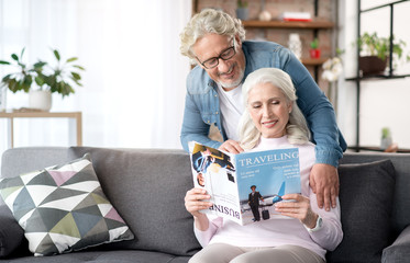 Joyful mature husband and wife entertaining at home together