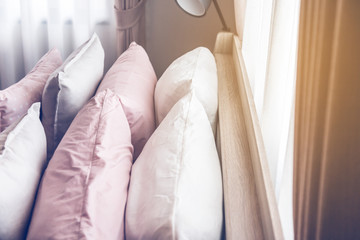 Bed maid-up with clean white pillows and bed sheets in beauty room. Close-up. Lens flair in sunlight.