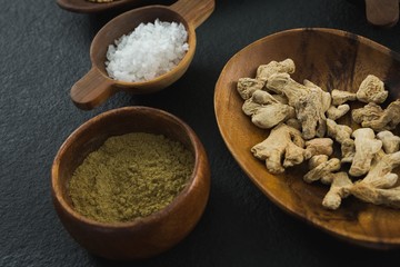 Dried ginger and coriander powder on black background