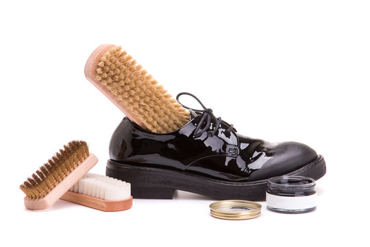 Leather shoes with a set for shoe service on a white background. Shoe care products.