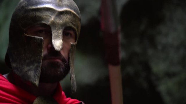 Close up shot of a medieval warrior in a helmet hiding behind his shield preparing to attack with the spear looking aggressive masculinity cosplay fighter war soldier historical concept.
