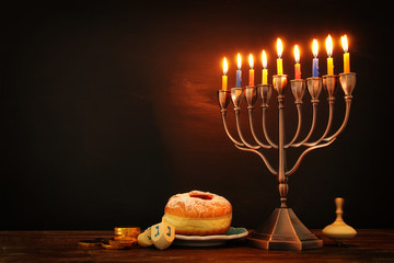 jewish holiday Hanukkah background with traditional spinnig top, menorah (traditional candelabra) and burning candles