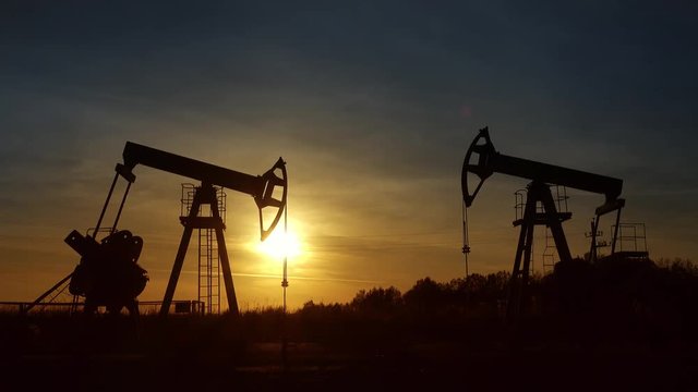 working oil pumps silhouette against sunset, 4k

