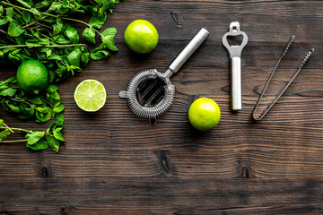 In the bar. Shake mojito. Lime, mint., barman tools on wooden background top view