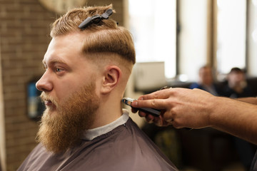 Man getting haircut by hairstylist at barbershop