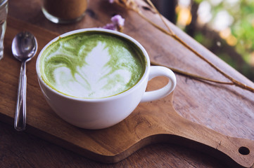 green tea hot drink latte white cup on wood table aroma relax time in coffee shop