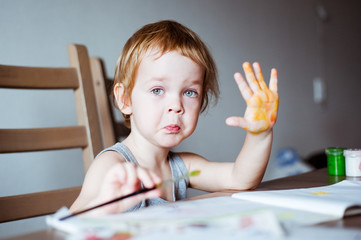 Cute little preschooler child drawing at home
