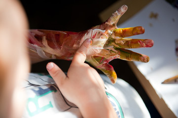 Baby hand in gouache paint.