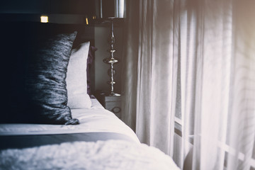 Bed maid-up with clean white pillows and bed sheets in beauty room. Close-up. Lens flair in sunlight.