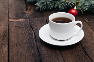 Christmas background with a cup of coffee on wood and xmas tree. Traditional festive Christmas dark background top view. Toned Vintage Effect.