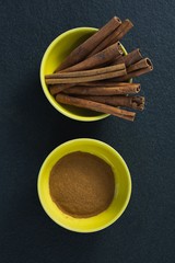 Cinnamon sticks and powder in a bowl
