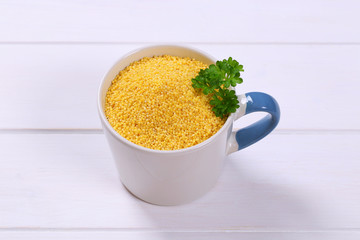 mug of raw millet grains