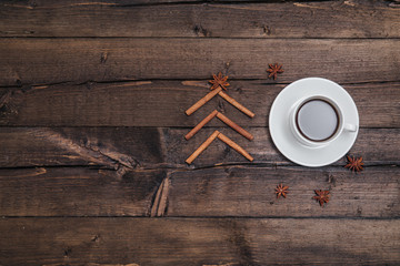 Christmas background with a cup of coffee on wood and xmas tree. Traditional festive Christmas dark background top view. Toned Vintage Effect.