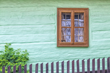 An ancient window on the wooden facade of the house.