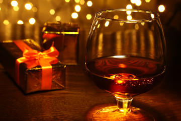 Whiskey, cognac, brandy and gift box on wooden table. Celebration composition on the light background.