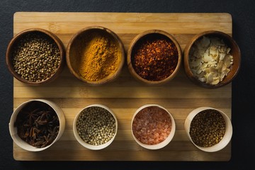Various spices in bowl on chopping board