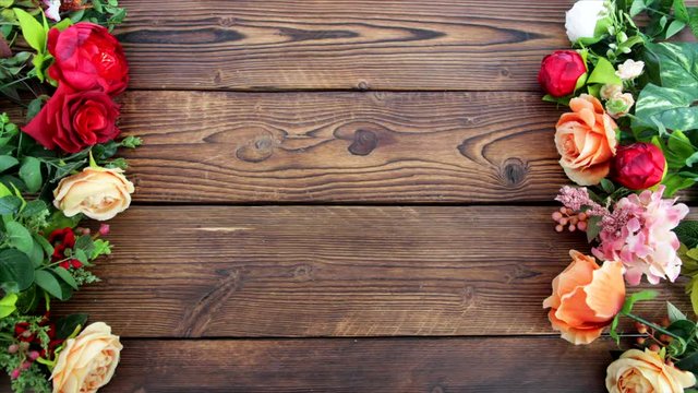 Stop motion. Beautiful flowers makes a frame on wooden table.