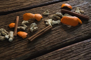Cinnamon sticks, orange peel and dried ginger on a wooden table