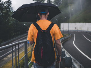 man backpacking in the mountain during the rain