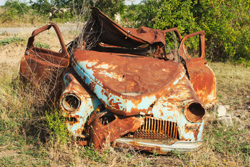 Rusted wrack of a car as a result of war in Azerbaijan in bombed abandoned city