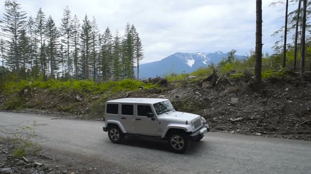 SUV driving through forest in mountains 