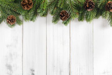 Christmas fir tree branches on white rustic wooden background with copy space for text