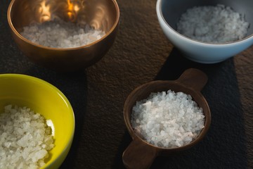Salt in various bowl on black background